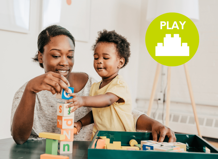 A mother and her toddler son play with stacking blocks