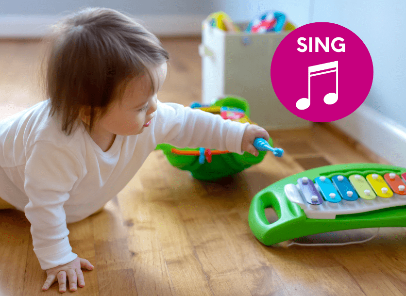 A one year old plays with a child xylophone